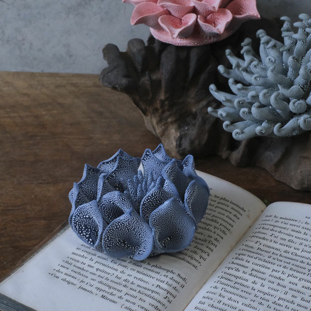 「ABYSSALブルーの花オブジェを本の上に飾った幻想的なシーン