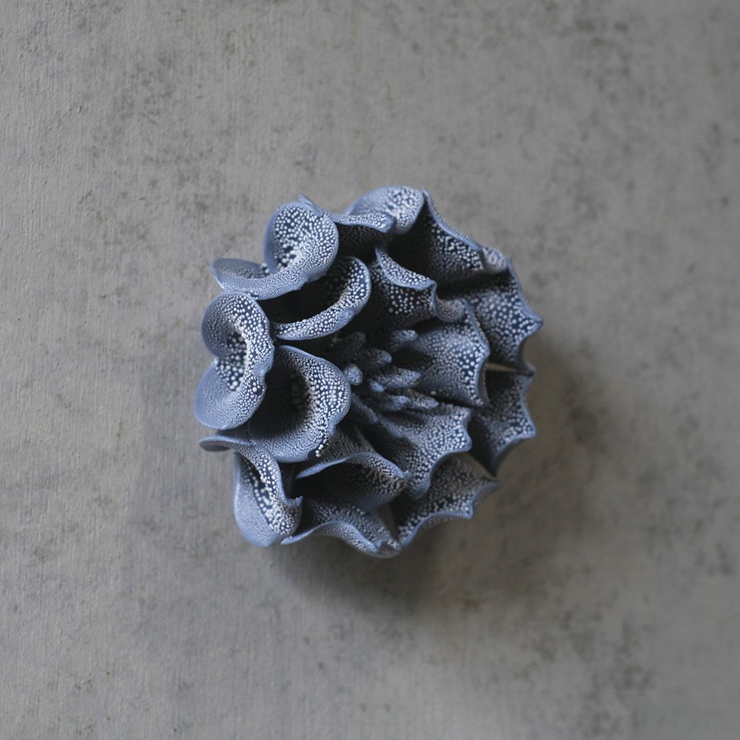 卓上に置かれたABYSSALブルーの花オブジェの上部から見た形状